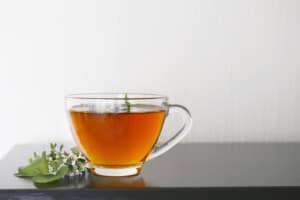 clear glass tea cup with hot herbal tea sitting on a counter